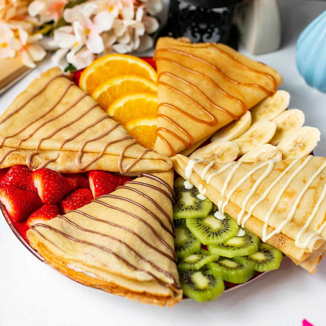 side-view-pancake-with-fruits-milk-chocolate-sauce-table